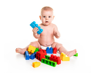 Baby boy plays with toy blocks over white background