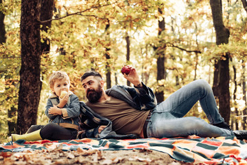 Father and son camping. Man with beard, dad with young son in autumn park. Happy joyful father with...