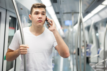 Man talking on phone in underground carriage