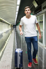 Fototapeta na wymiar Man with luggage bag in subway station