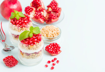 Pomegranate parfait - sweet organic layered dessert with granola flakes, yogurt and ripe fruit...