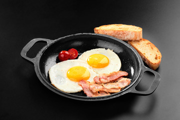 Salted egg and sprinkled with black pepper. English breakfast. Grilled bacon, two eggs on pan menu black background copy