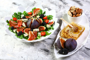 delicious figs, arugula, dorblyu cheese and nuts salad, light background, top view, copy space