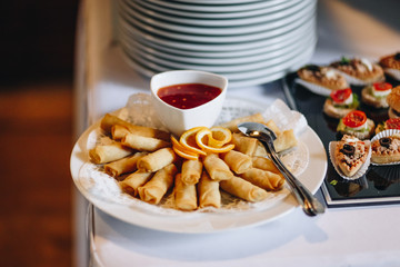 top view of spring rolls with dip at a outdoor wedding party