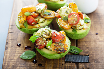 Avocado stuffed with pesto caprese salad