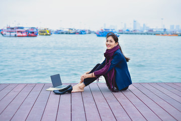 Take off work concept. Young businesswoman is cheerful at the seashore. Beautiful girls choose to relax instead of work.