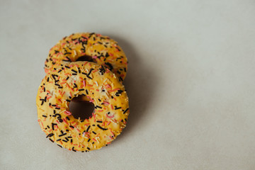 Yellow donuts biscuits on gray background with copy space, sweet food