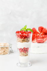 Pomegranate parfait - sweet organic layered dessert with granola flakes, yogurt and ripe fruit seeds.