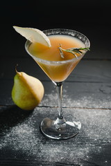 yellow christmas alcohol cocktail italian pear with pear nearly on the table on dark background
