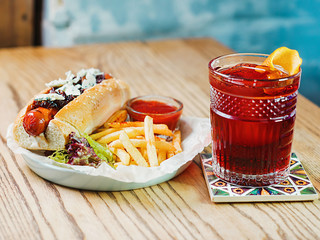 plate with hot dog with sausage and dor blue cheese, tomato sauce ketchup and french fried and old...