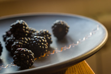 large juicy blackberry berries on a ceramic plate