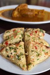 Garlic and cheese naan served with curry.