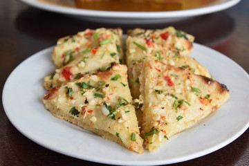 Garlic and cheese naan served with curry.