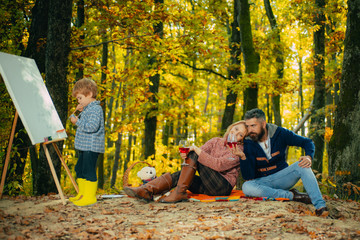 Camping with kids. Little artist painting picture. Autumn garden party Father, mather and son. We...