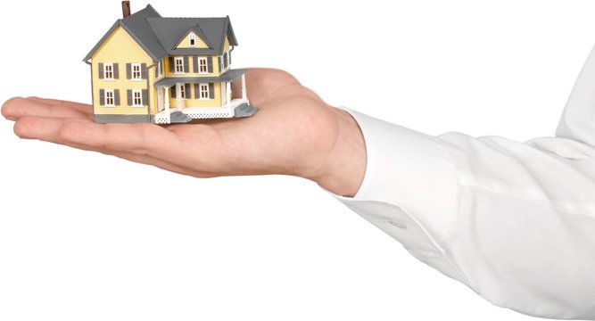 Men's Hand Holding a Model of a House - Isolated