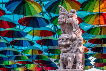 Chinese sculpture with colorful umbrella in the background
