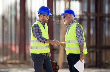 Engineers shaking hands on construction site