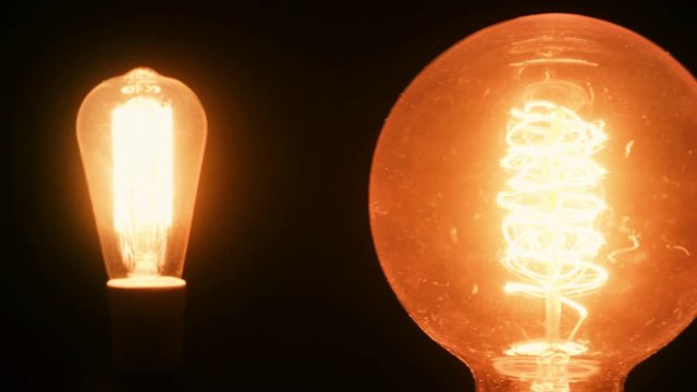 Two light bulbs glowing - pan shot