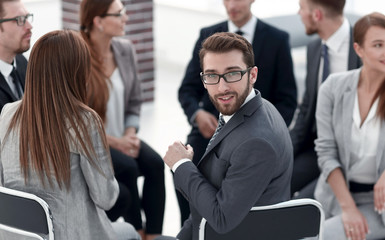 young employee sitting in a circle of colleagues