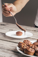 Covering homemade muffins with chocolate 