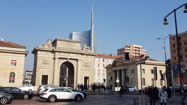 Time lapse in a central point of Milan where the road is trafficked by people and motor vehicles