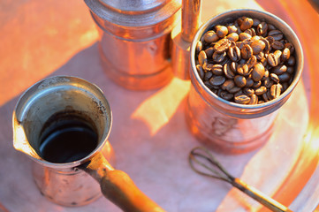 close up coffee beans to in a copper container on a dark background