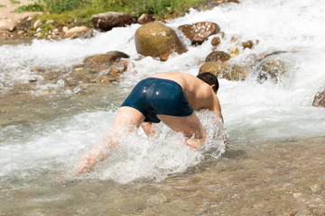 man bathes in a cold mountain water