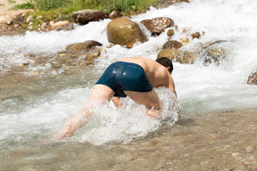 Fototapeta premium man bathes in a cold mountain water