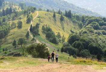 Family father, mother and child are traveling in the mountains