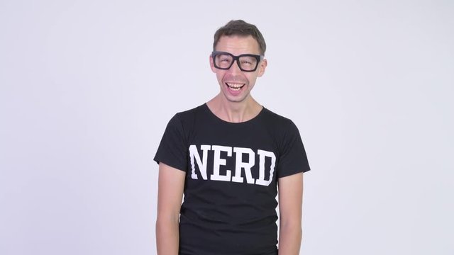 Studio shot of happy nerd man laughing and pointing to camera
