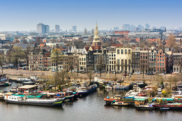 Fototapeta na wymiar AMSTERDAM, NETHERLANDS - APRIL 10, 2018: Amsterdam skyline cityscape from the Oosterdok in the Netherlands. The Oosterdok is a chanel in Amsterdam .