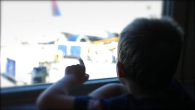 Cute Little Boys Sit And Watch Airplanes From The Window At The Airport