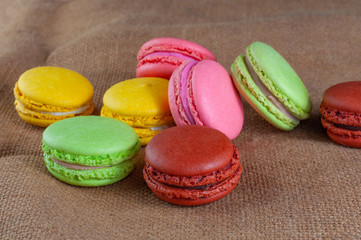 Macarons cakes of different colors on a burlap