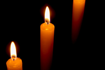 candle lit brightly against a black background