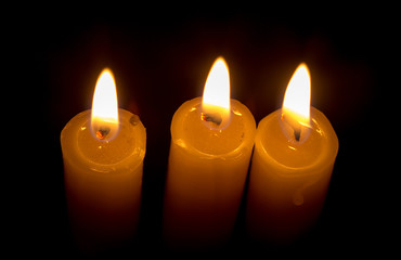 candle lit brightly against a black background