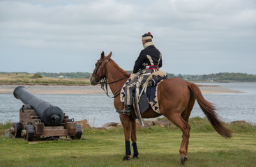 Reenacter Hussar on horse next to cannon