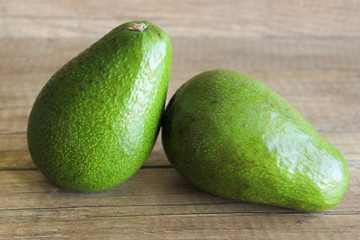 Avocados on a wooden table. Healthy food, diet. Two avocados