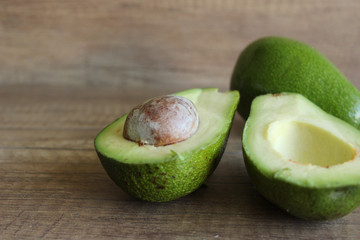 Avocados on a wooden table. Healthy food, diet. Cut avocado