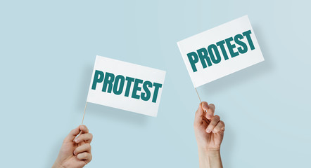 Hands are holding flags with the word PROTEST. Linking to protest, rebellion against the state, employer. Manifestation against ill-treatment, increases, small incomes.