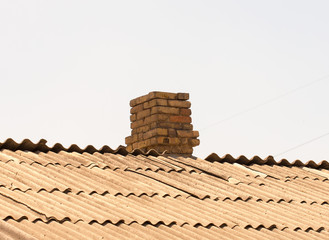 brick chimney on the roof of asbestos