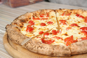 Tasty Italian oven baked pizza on wooden table in restaurant