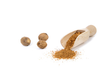 Nutmeg and ground nutmeg on white background, isolated. Nutmeg on the bucket. The concept of seasoning dishes, using spices and herbs for meals.