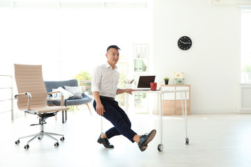 Young businessman doing exercises in office. Workplace fitness