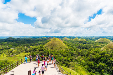 BOHOL, PHILIPPINES - FEBRUARY 23, 2018: People on the background of Chocolate hills on sunny day.