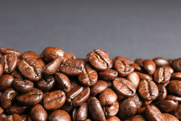 Roasted coffee beans on grey background, closeup