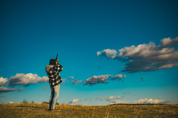 Hunter with Powerful Rifle with Scope Spotting Animals. Hunter with shotgun gun on hunt. Copy space for text. Most realistic hunting game ever created.