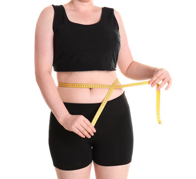 Overweight woman measuring waist before weight loss on white background