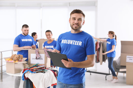 Male volunteer with clipboard listing donations indoors