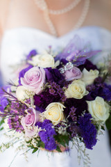 Bride holding bouquet of purple flowers
