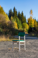 Single white wooden chair outdoors on gravel
